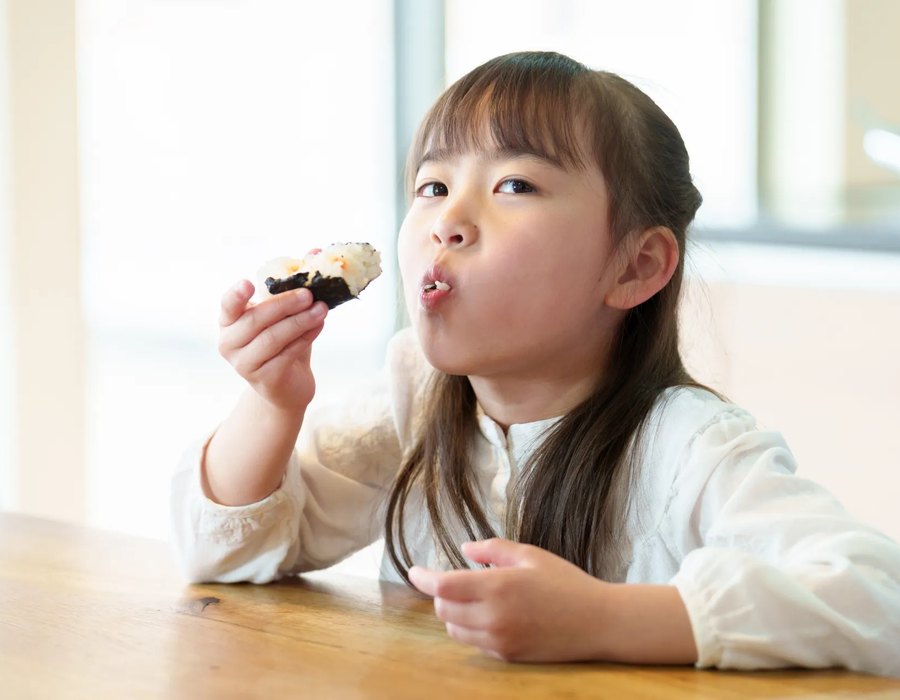 ハツシモで作ったおにぎりを食べる子ども